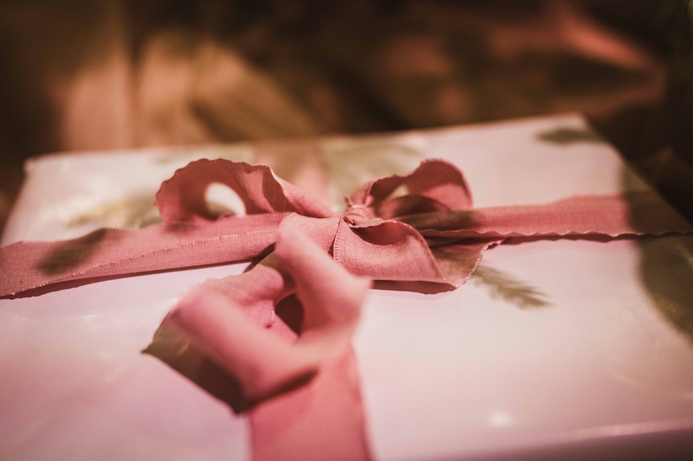 Hands tying a ribbon around a wrapped gift
